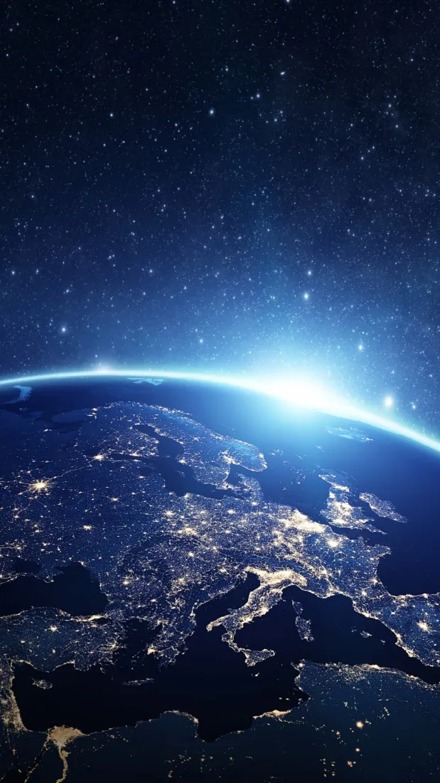 从太空俯瞰地球夜景，地表城市灯火璀璨，上方是布满繁星的深蓝色宇宙。