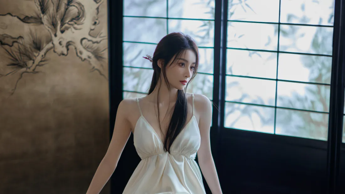 6k白裙美女壁纸|窗边古风室内背景图片 - 温婉写真「哲风壁纸」 身着白色吊带裙的长发女子立于格窗旁,侧头望向画面右侧,背景有水墨墙绘。