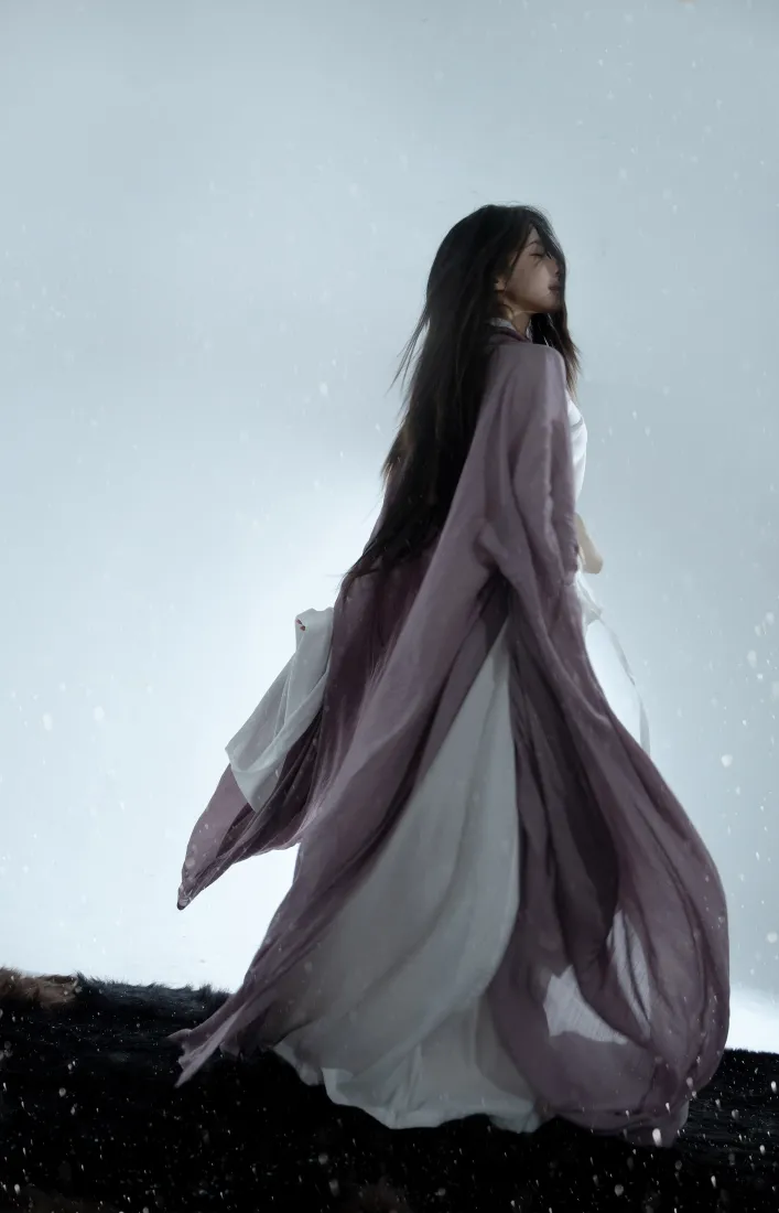 身着紫纱白裙的长发古风少女立于落雪暗地，衣袂随风扬起，氛围清冷空灵。