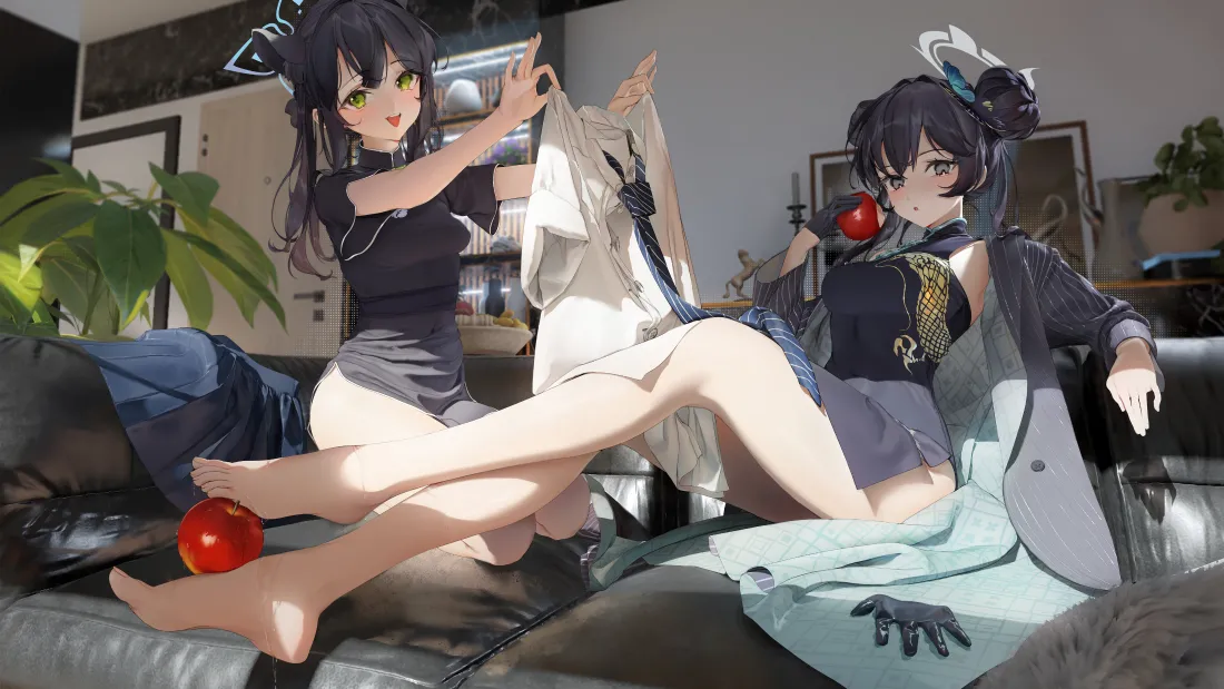 两名身着黑色旗袍的黑发少女在居家沙发上嬉闹，脚边放着红苹果。