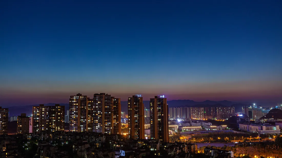 3k都市夜景壁纸|城市高楼背景图片 - 暮色「哲风壁纸」 暮色渐变天空下的城市高楼群,万家灯火初上,远处山峦朦胧。