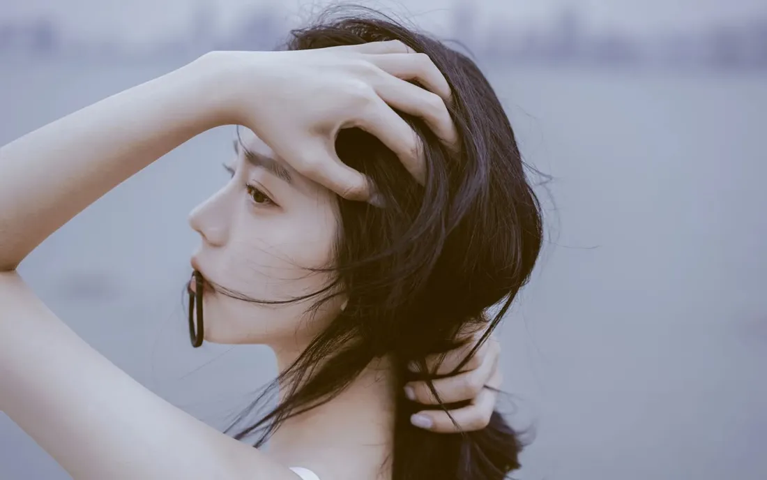 2k魅力美女壁纸|朦胧水畔背景图片 - 优雅瞬间「哲风壁纸」 朦胧水畔背景下,长发女性侧身抬手整理发丝,氛围柔静。