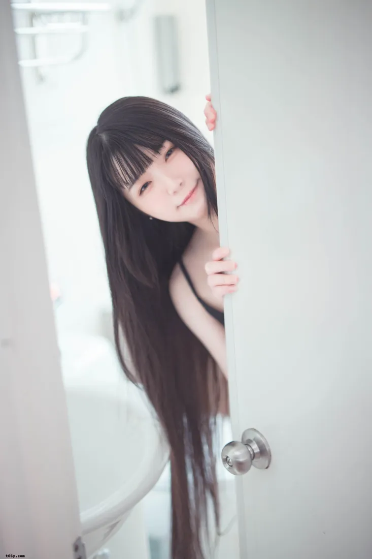 黑长直齐刘海长发女生从门后探出头，手扶门面带浅笑。