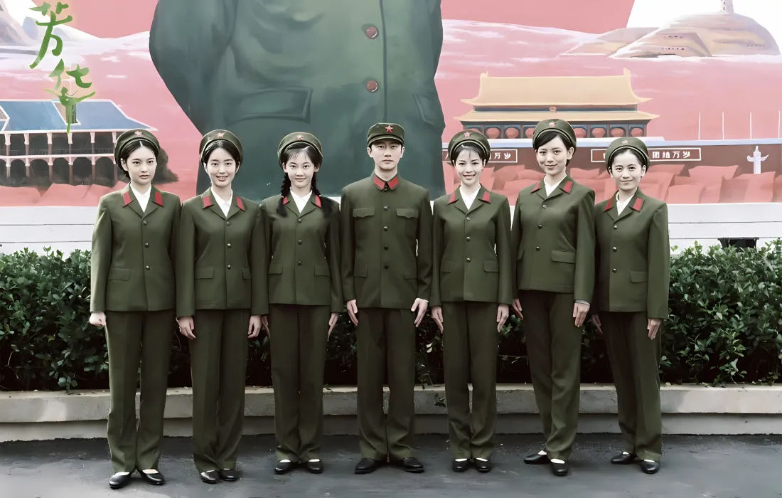 《芳华》群像，七人身着绿色军装在红色主题壁画前合影。