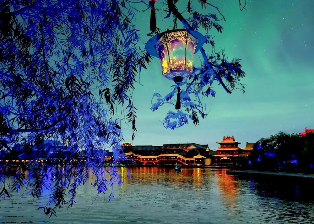 2k古风夜景壁纸|河边灯笼背景 - 古建筑柳树「哲风壁纸」 夜晚河畔,蓝调垂柳悬着中式宫灯,远处古建筑灯火倒映水面。