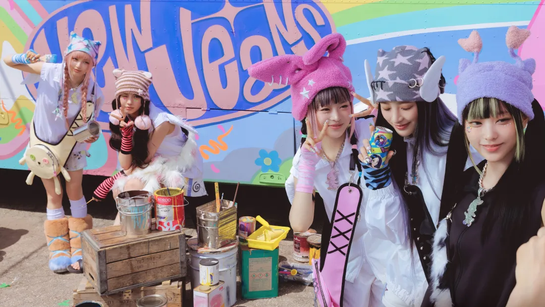 NewJeans五名成员身着可爱甜酷穿搭，在涂鸦背景前活泼合影