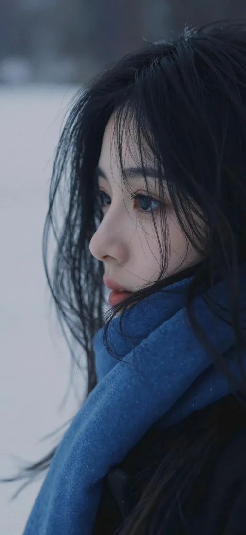 冬日雪景中戴蓝色围巾的长发女生侧脸特写，背景虚化清冷。