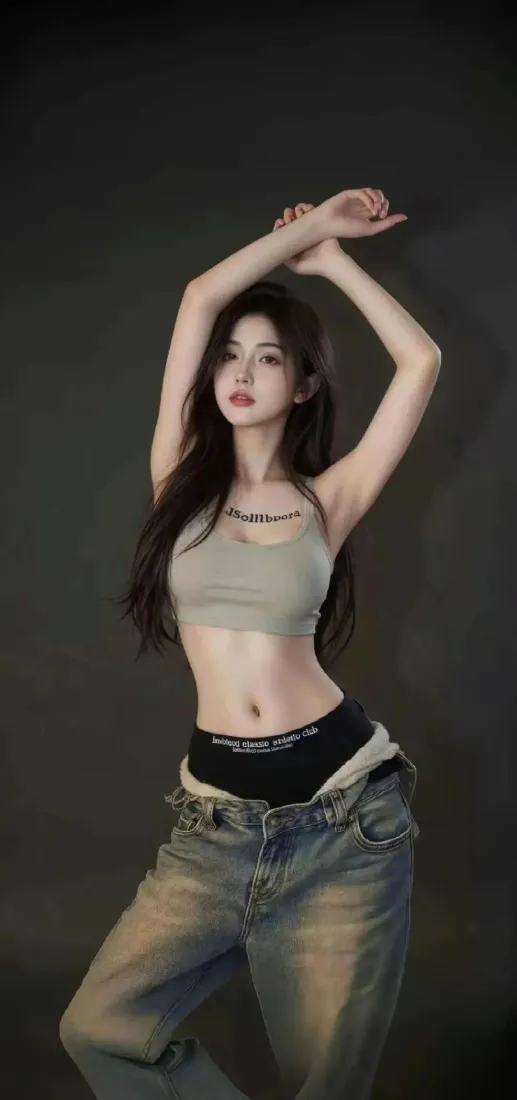 暗调背景下，长发年轻女性身着灰背心与牛仔裤，双臂举过头顶摆姿。