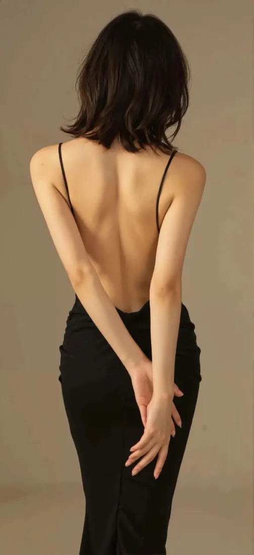 短发女性背对镜头，身着黑色露背吊带长裙，双手交叠于身后