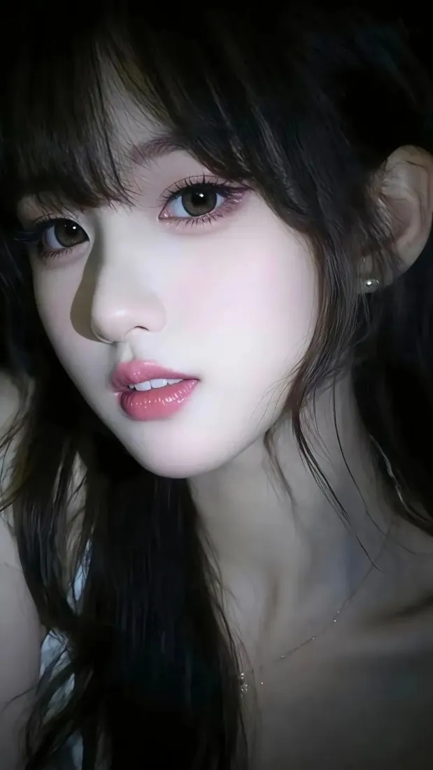 暗色背景下的长发年轻女性脸部特写，妆容精致，氛围柔和。