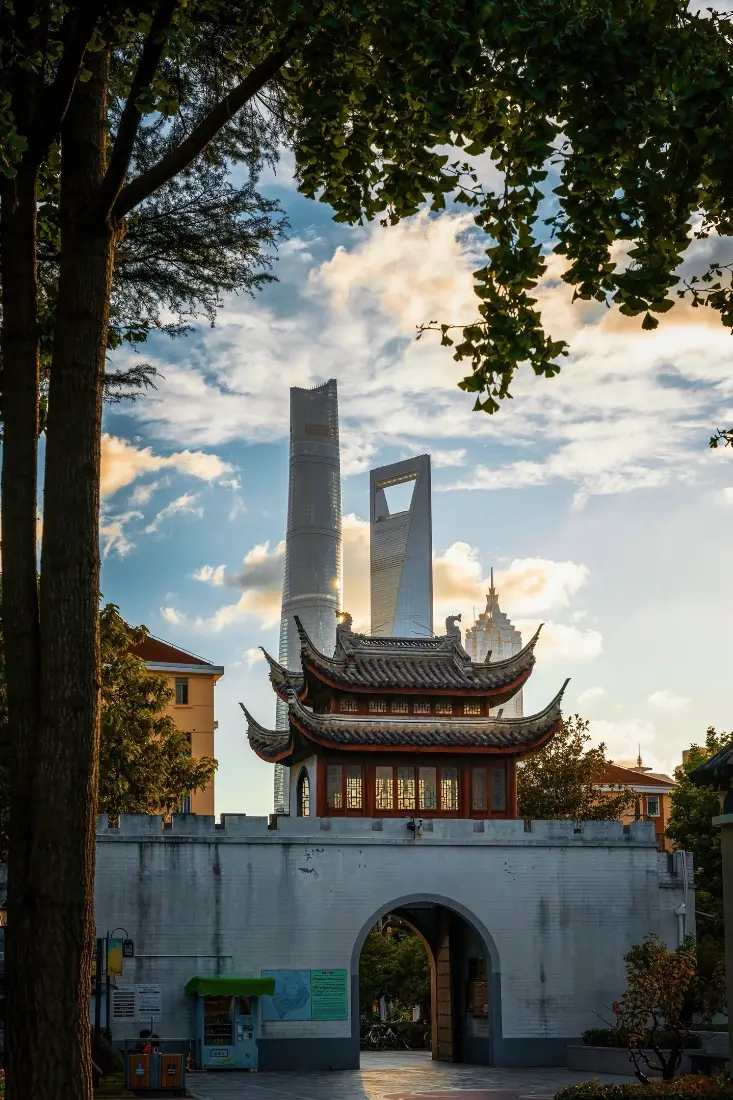黄昏时分上海中式城楼与后方现代摩天大楼同框的城市街景