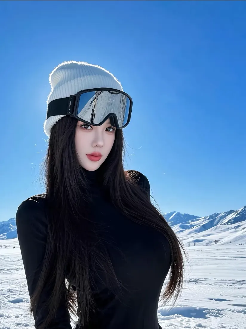 戴针织帽与滑雪镜的黑衣长发女性，立于雪山雪地蓝天背景前
