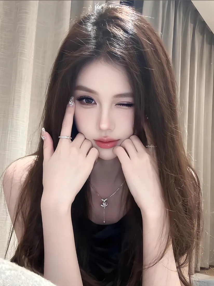 室内窗帘前，长发黑衣女子双手托脸，单眼眨眼wink，佩戴项链与戒指。