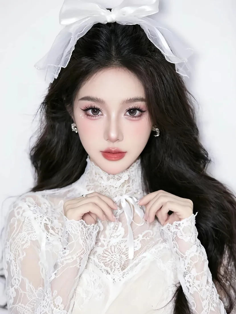 纯白背景前，头戴白色蕾丝蝴蝶结的黑长卷发女子身着白色蕾丝立领上衣，双手轻扶领口。