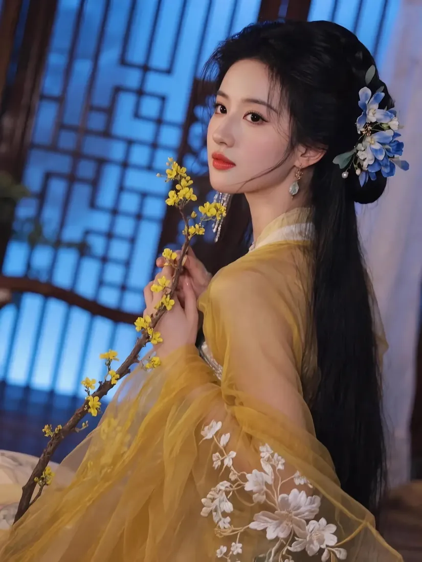 身着黄色汉服的女子手持黄花枝，背景为中式蓝调窗格