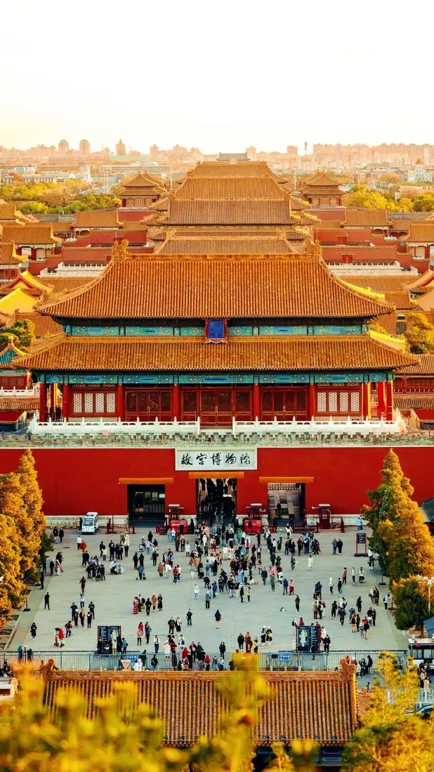 黄昏时分俯瞰故宫博物院正门，红墙黄瓦，广场上游客往来。