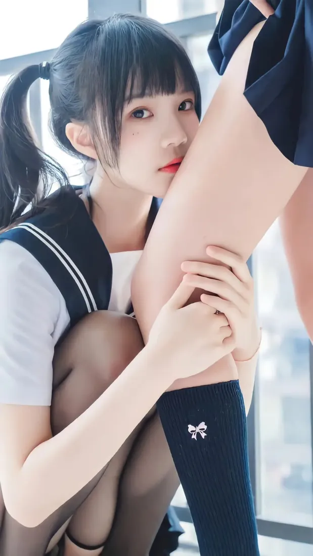 窗边室内，两名穿水手服的少女亲密互动，一人抱另一人腿部