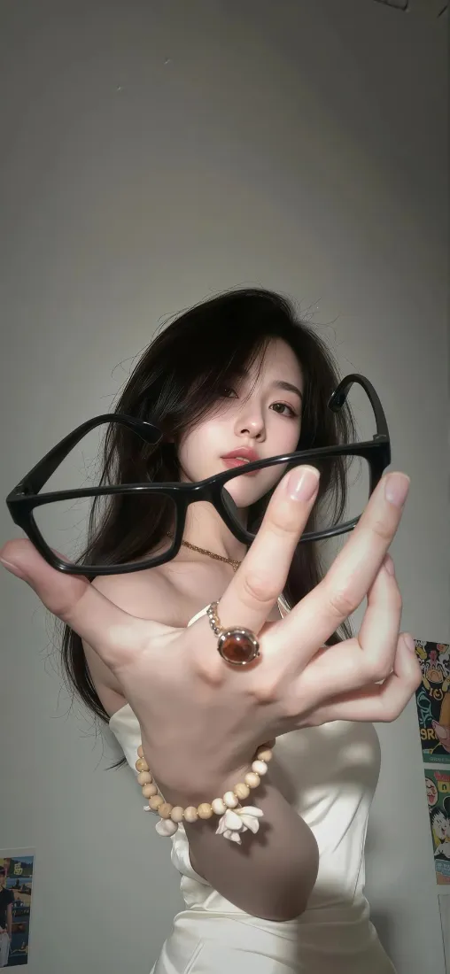 室内白衣长发女生手持黑框眼镜，佩戴戒指与珍珠手链自拍