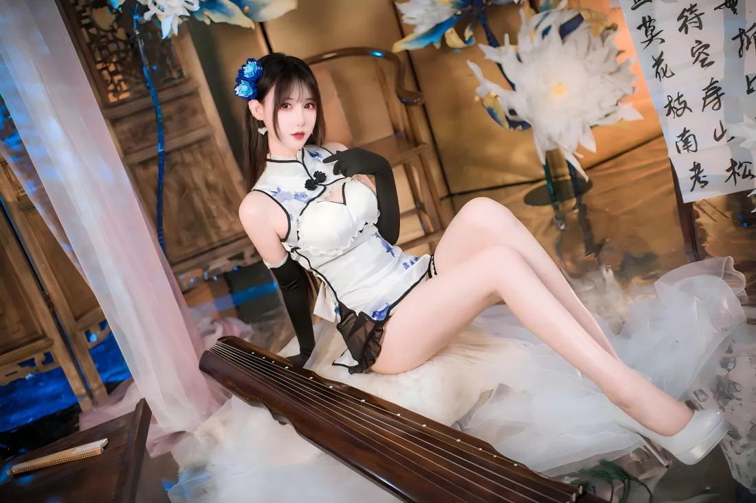 身着白蓝短款旗袍的女性坐于古风布景中，身旁摆放古琴，背景有书法与木格屏风。