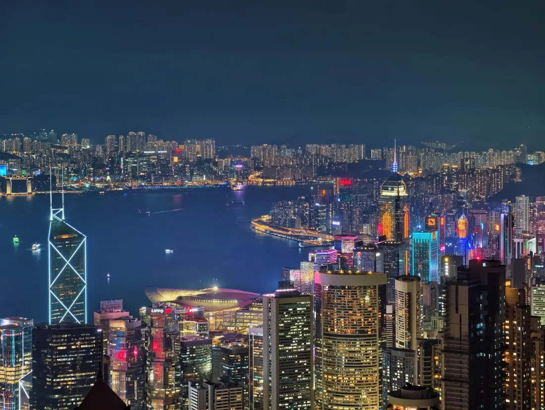 香港维多利亚港夜景，俯瞰璀璨摩天楼群与港湾水面，灯火繁华。