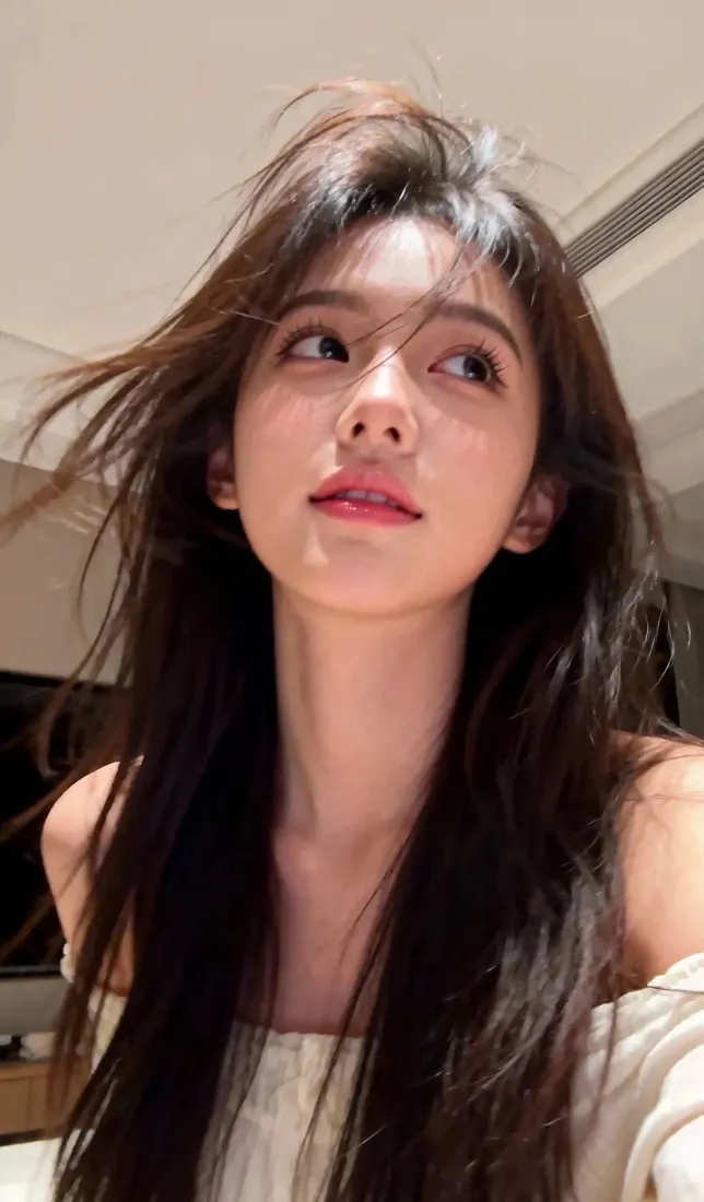 室内自拍的长发年轻女性，穿露肩白衣，红唇，发丝自然飘动。