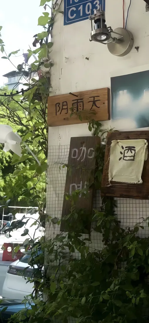 爬满绿植的临街小店墙面，挂有木质招牌与路牌，旁侧街道停有车辆。
