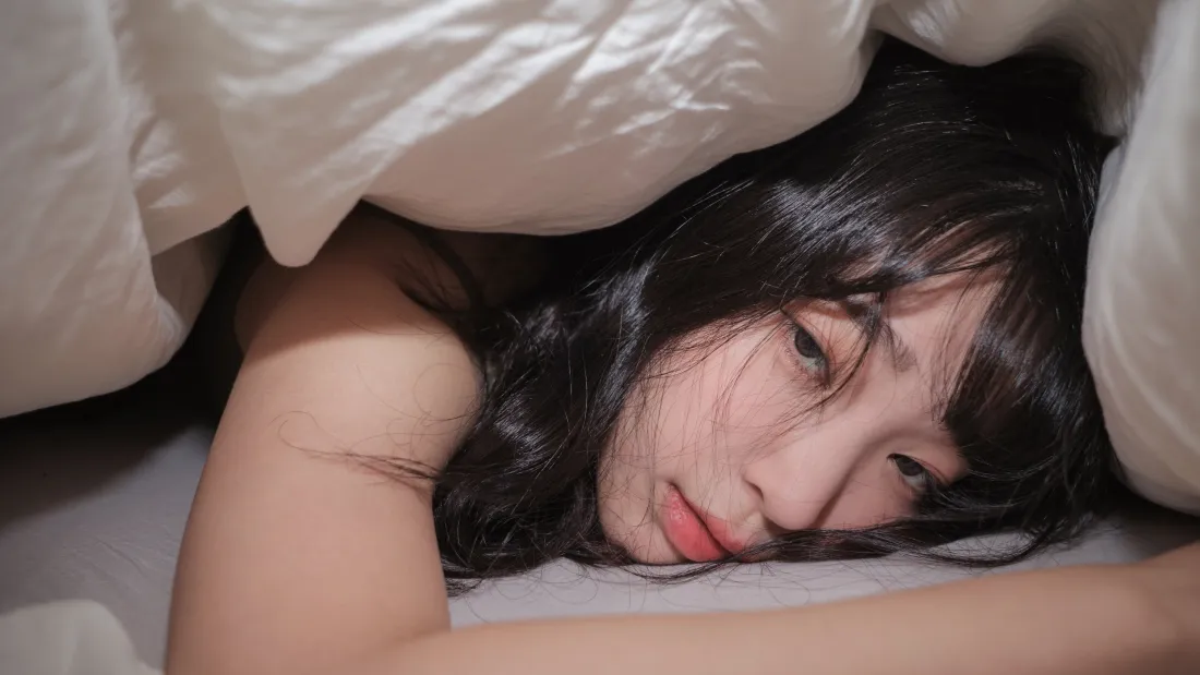 4k姜仁卿壁纸|居家背景图片 - 醉酒睡颜「哲风壁纸」 黑发年轻女性裹在白色被褥中,慵懒趴卧,眼神迷离看向镜头