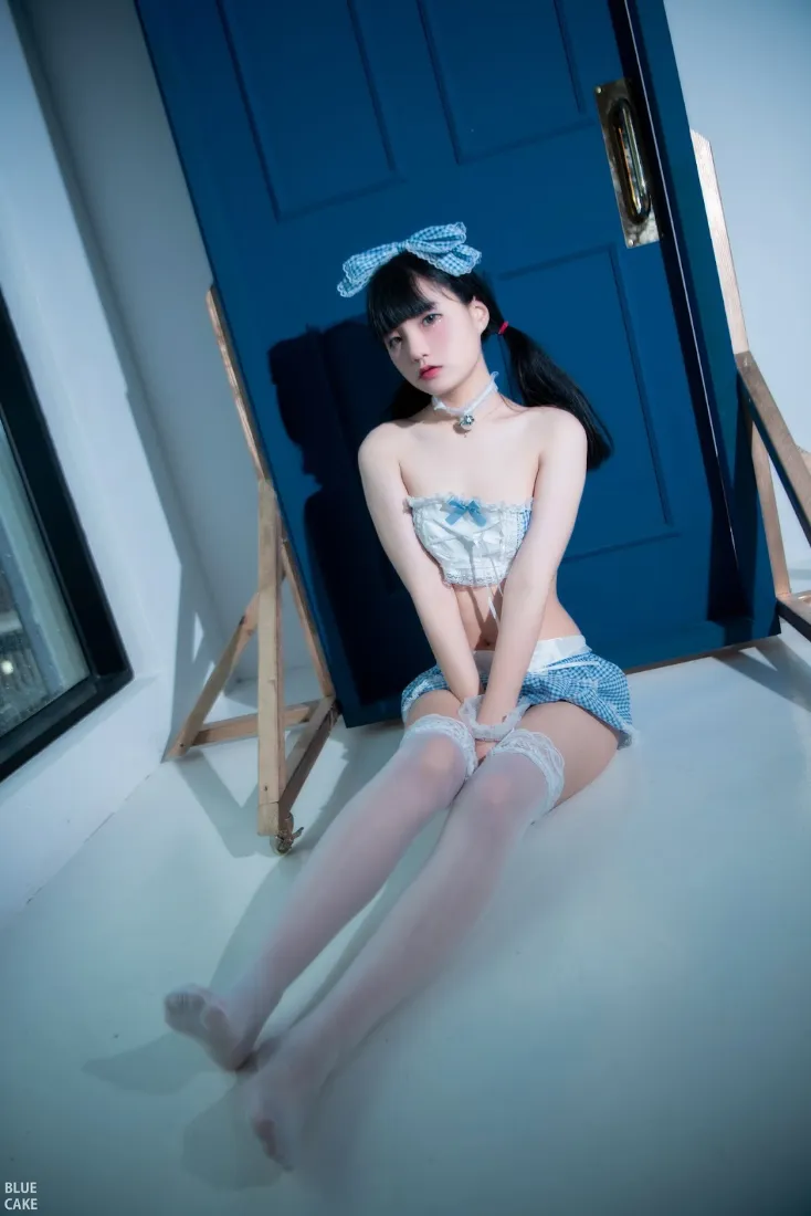 双马尾少女戴蓝色格纹发带，穿蓝白格纹抹胸短裤与白丝袜，坐于蓝色门前地面。