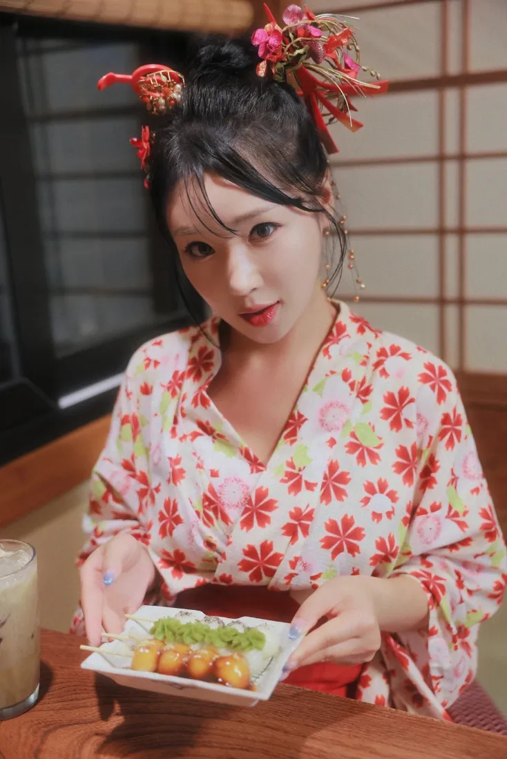 身着樱花纹样和服的女子在日式室内手捧章鱼小丸子餐盘点缀饮品