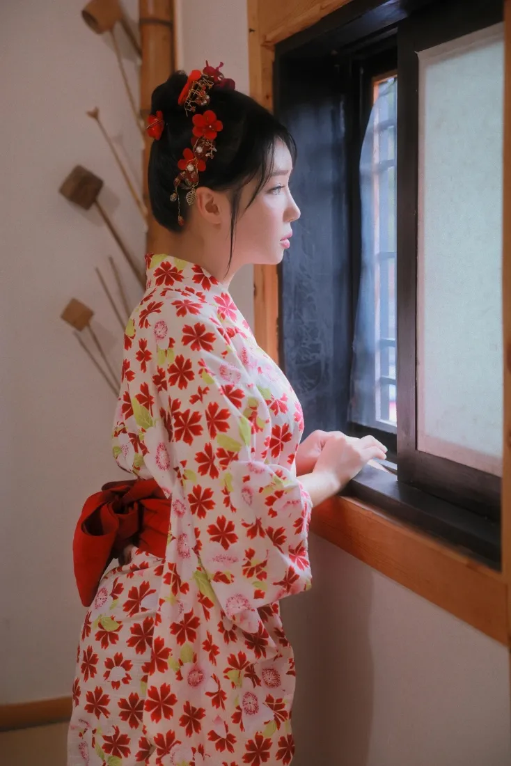 身着红花和服的女子侧身立于日式窗边，望向窗外，氛围静谧。