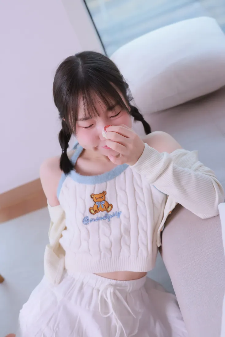 双马尾少女穿小熊图案白色居家服，在室内沙发旁揉眼，氛围慵懒可爱。