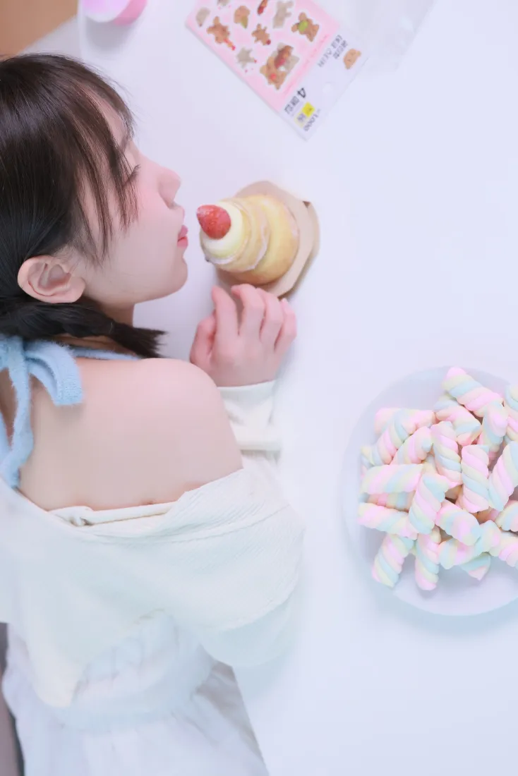浅衣蓝丝带少女侧坐手持小蛋糕，旁侧摆放一盘棉花糖，氛围甜美柔和