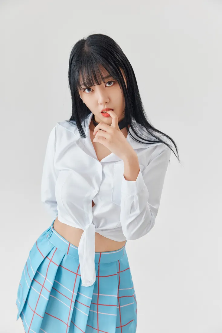 黑长直齐刘海年轻女性，着白色短款衬衫与蓝格百褶裙，浅灰纯色背景写真。