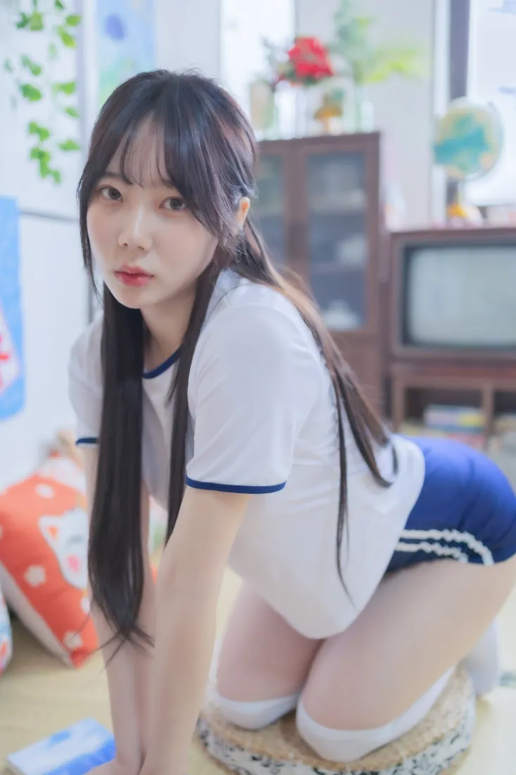长发女生穿白蓝运动装白袜，在韩式居家房间内蹲坐看向镜头