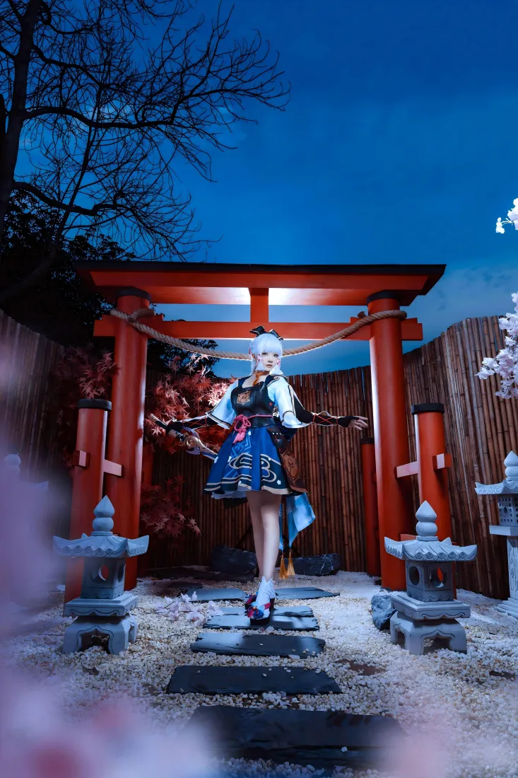 夜晚日式庭院中，白发coser站在红色鸟居下的石板路上，周围有石灯笼与樱花。
