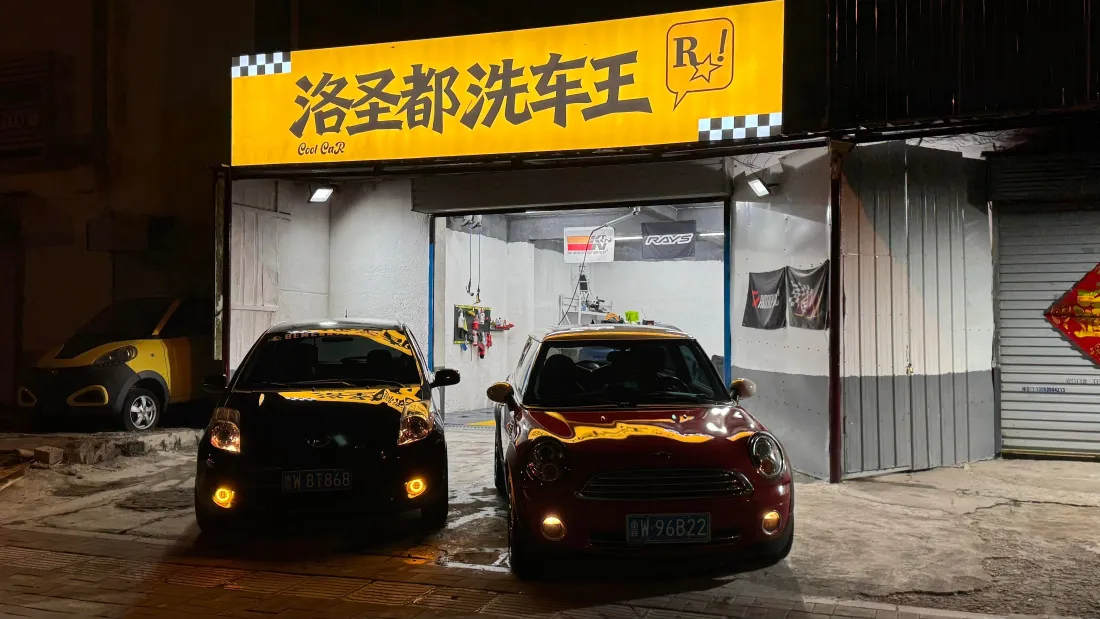 4kGTA5壁纸|洛圣都洗车店背景图片 - 现实恶搞场景「哲风壁纸」 夜晚实景洗车店挂着洛圣都洗车王招牌,门前停两辆改装小车,GTA恶搞风