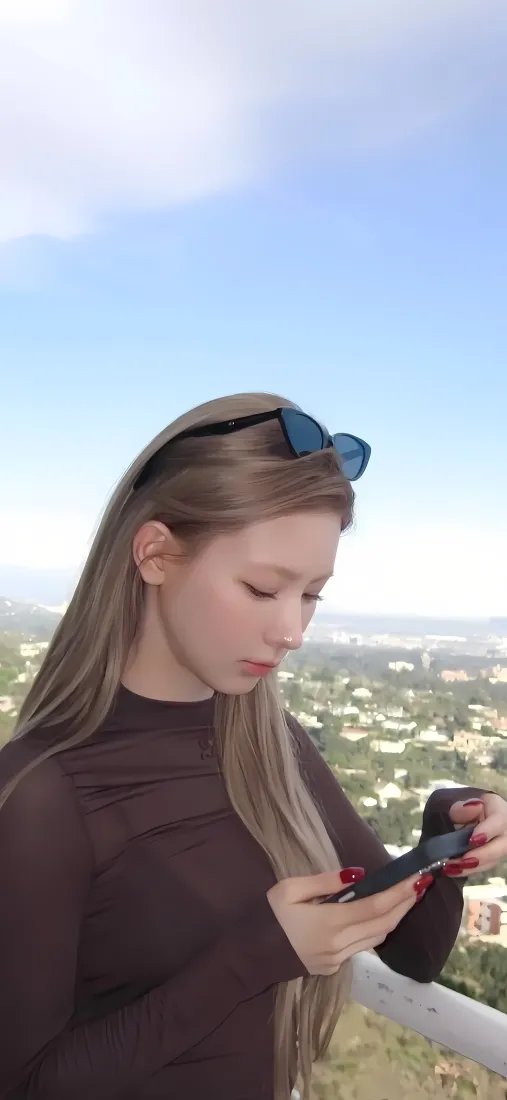 赵美延户外蓝天背景下低头看手机，头顶架墨镜，远处是城市远景