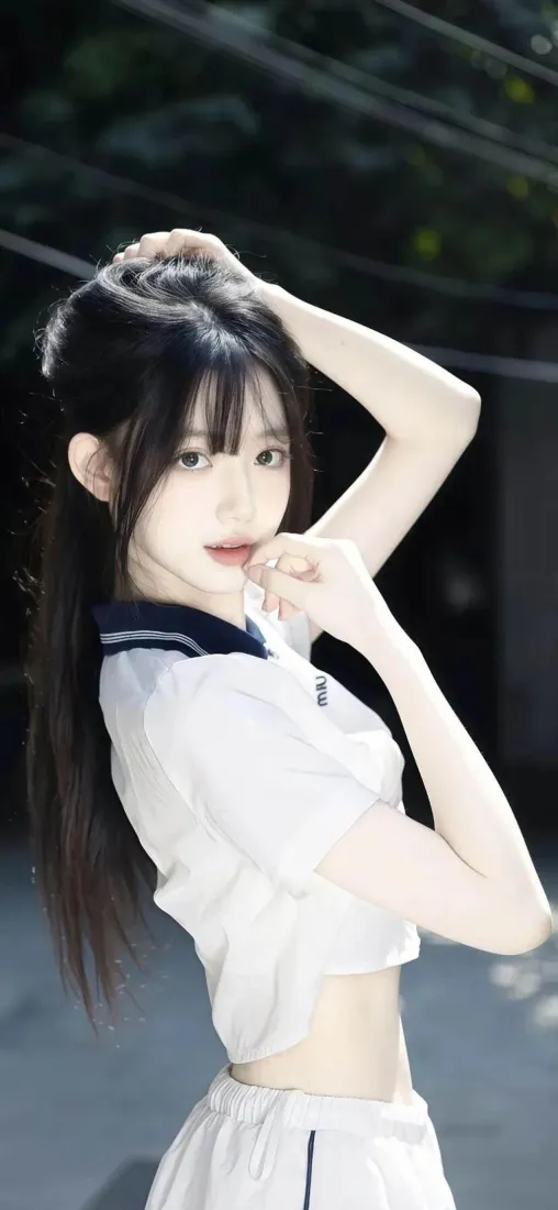 夜晚户外，穿露腰水手服的清纯少女侧身抬手整理长发，看向镜头。