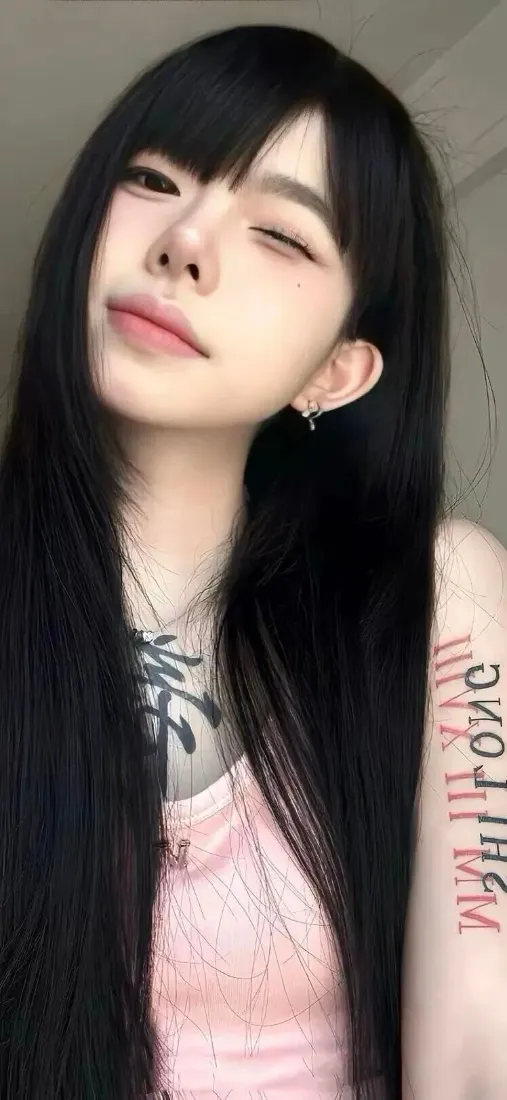 黑长直齐刘海女生wink自拍，穿粉色上衣，手臂与锁骨处有纹身。