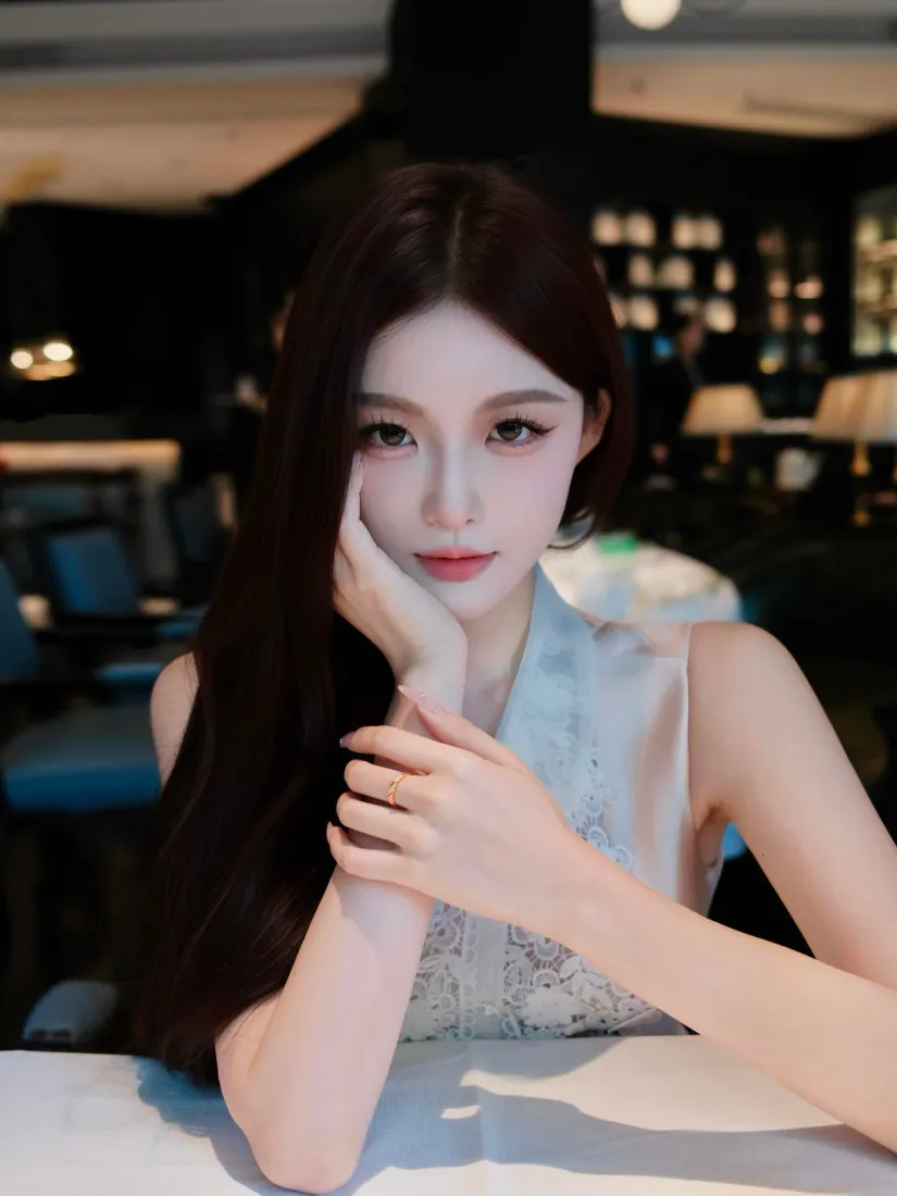 长发女子手肘撑在桌面，手托脸颊，身处昏暗咖啡厅内。