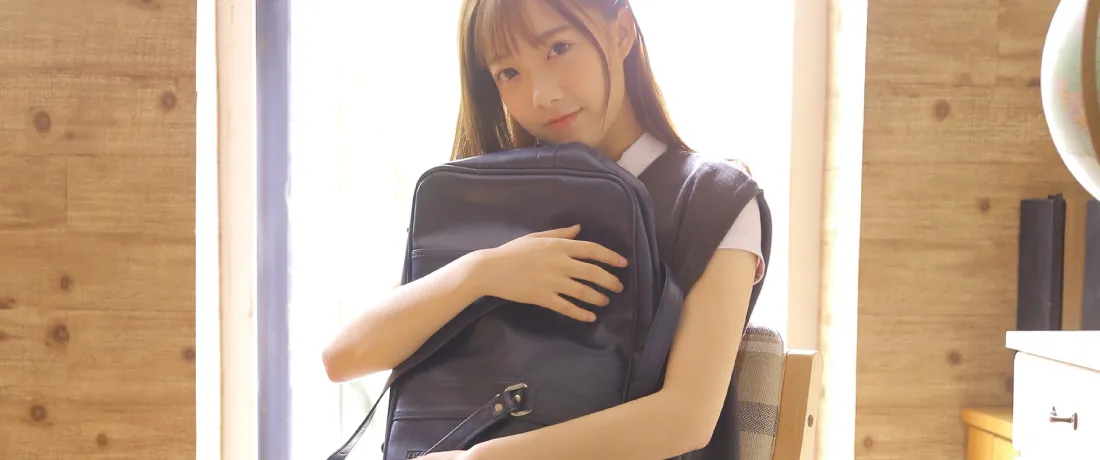 3k甜美制服少女壁纸|室内居家背景图片 - 怀抱黑色背包「哲风壁纸」 暖光室内,长发制服少女怀抱黑色背包,身后是明亮窗光与木质墙面