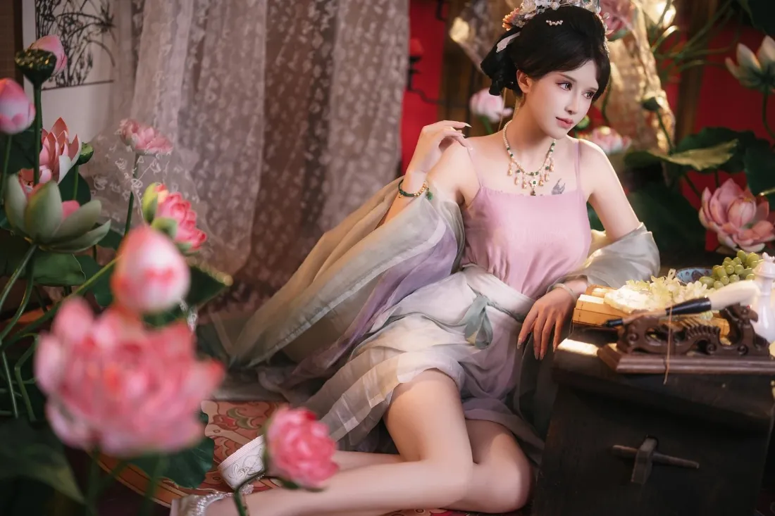2k古风美女壁纸|荷花雅致场景背景图片 - 温婉汉服写真「哲风壁纸」 身着粉纱古风服饰的女子倚坐桌旁,周围环绕粉色荷花,氛围温婉雅致。