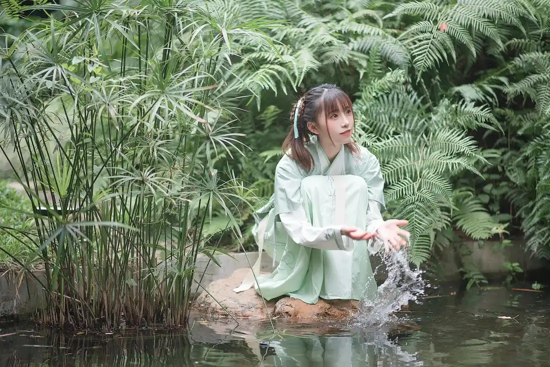 6k绮太郎Kitaro壁纸|溪边绿植背景图片 - 汉服少女写真「哲风壁纸」 身着浅绿汉服的少女蹲在溪边石上,抬手溅起水花,四周绿植环绕。