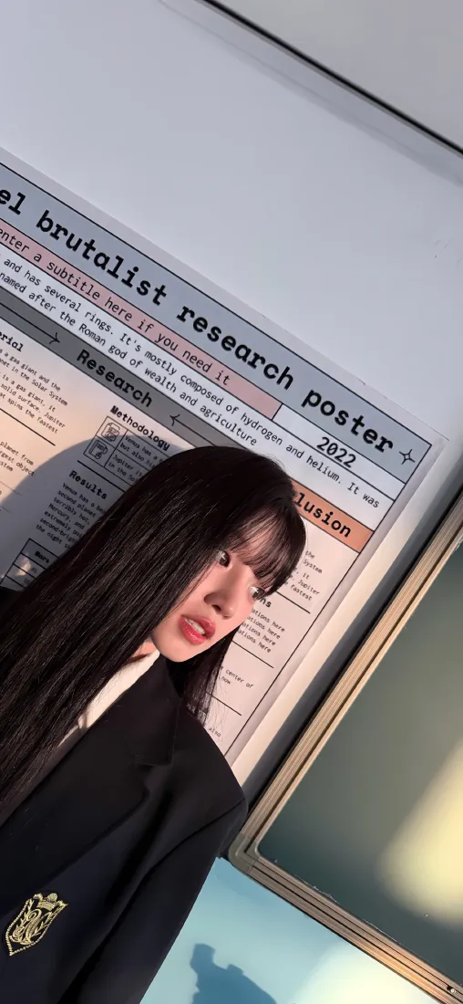 黑长直齐刘海少女身着黑色校服，在贴有研究海报的教室前自拍