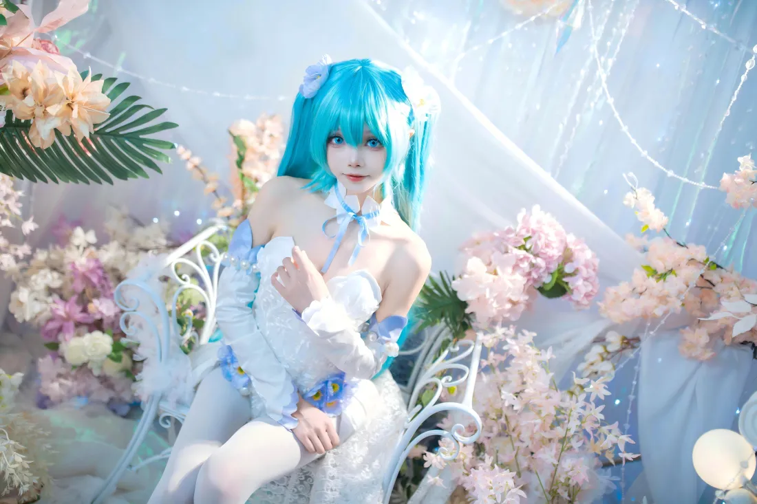 8k初音未来壁纸|花艺纱幔背景图片 - 美女cos写真「哲风壁纸」 蓝发双马尾coser身着白蓝礼服,坐于花艺纱幔布景中,氛围梦幻柔美