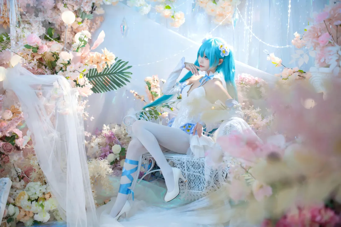 蓝发花嫁初音未来coser坐于花丛纱幔间，白裙白丝，氛围梦幻柔美