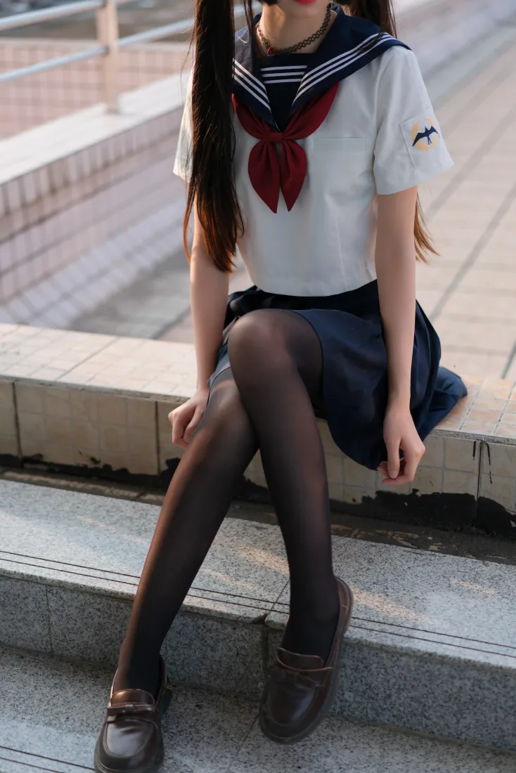 穿水手服黑丝的双马尾少女坐在户外石阶上，头部被裁切。