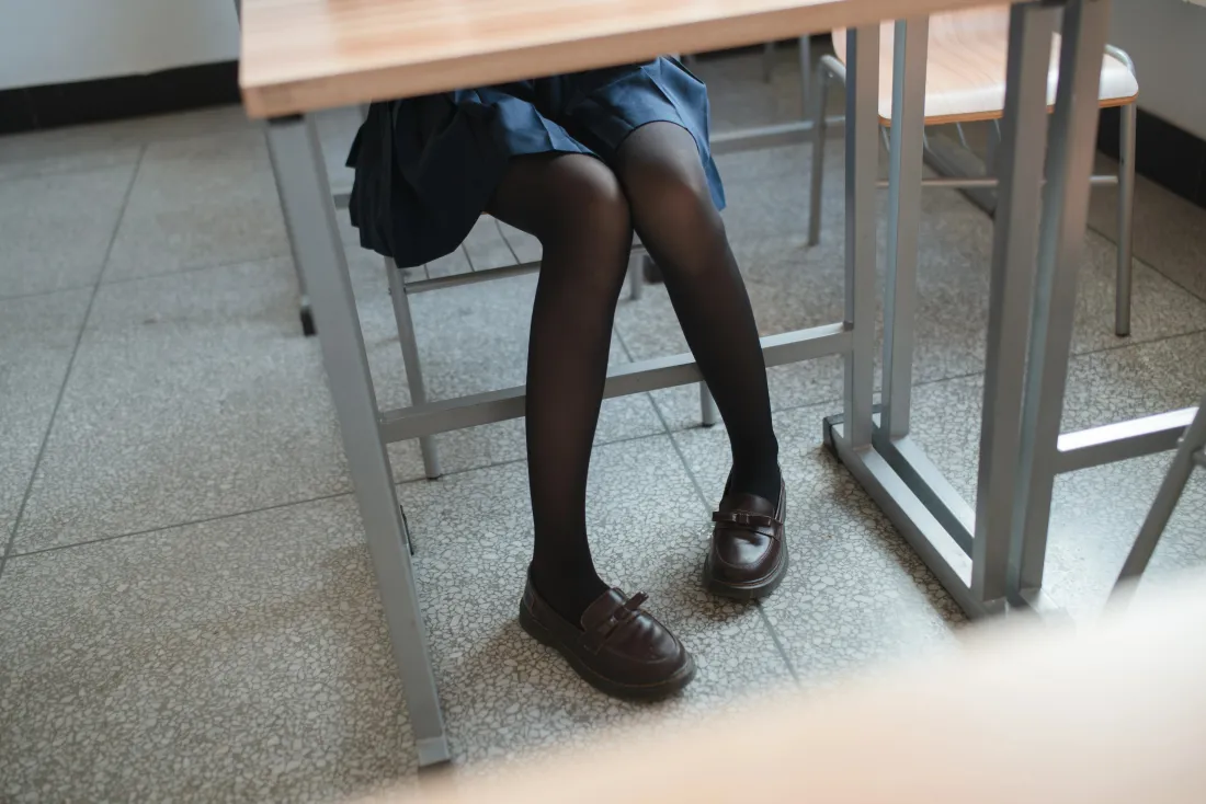 教室课桌下，穿JK制服黑丝皮鞋的女生坐姿腿部特写