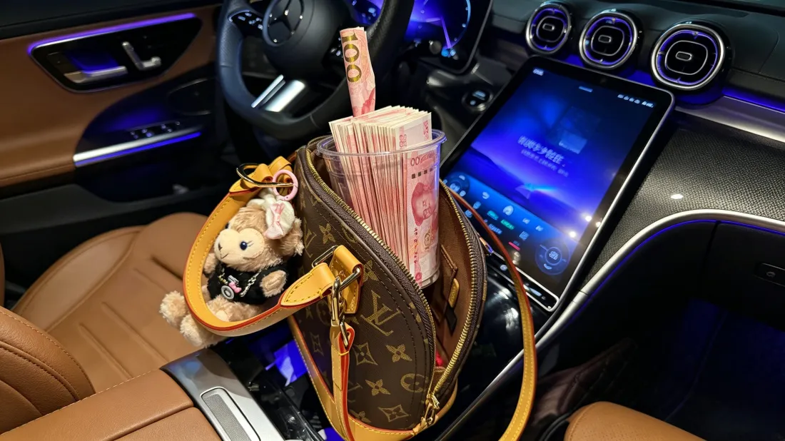 3k车内奢侈品现金壁纸|轻奢氛围感背景图片 - 高端质感「哲风壁纸」 汽车内饰中控台上放置装满人民币的LV包,搭配蓝色氛围灯与毛绒公仔