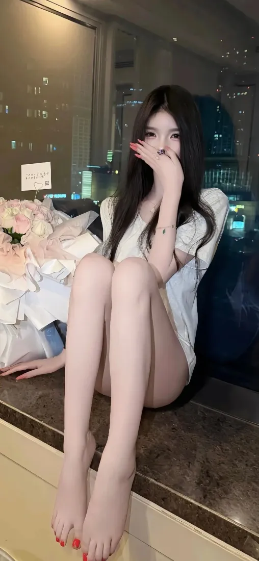 黑长直白衫美女坐于窗台，光脚红美甲，身后是城市夜景